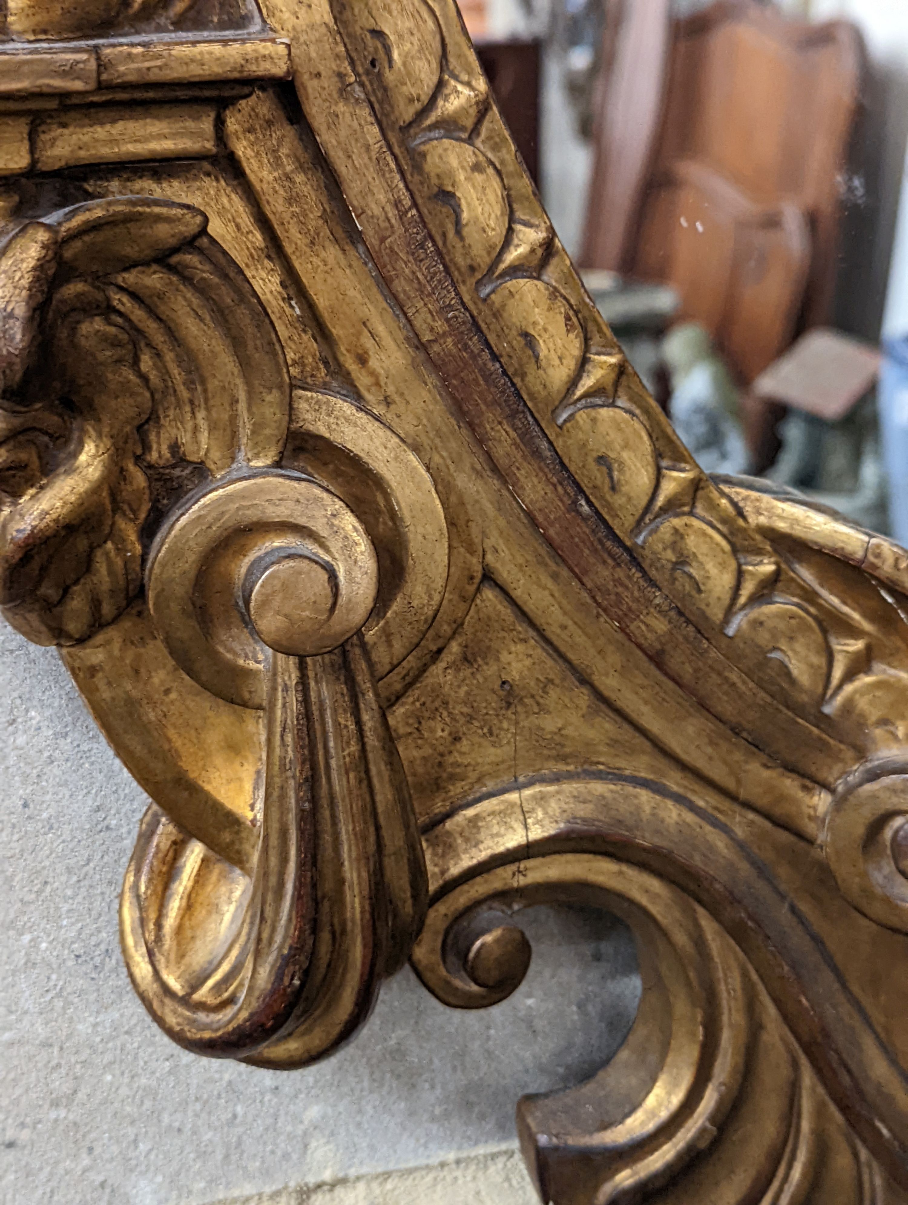 A Victorian carved giltwood oval wall mirror decorated with cherubs and C scrolls., width 74cm, height 110cm